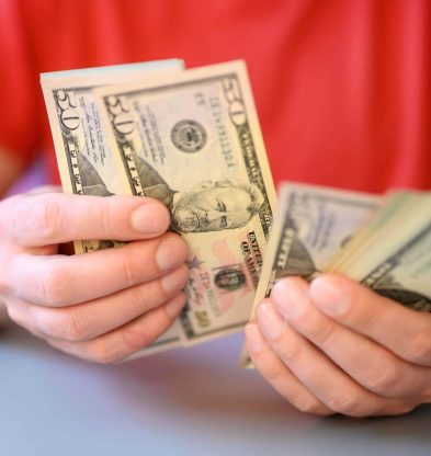 men-s-hands-hold-and-count-50-dollar-bills-on-gray-2022-11-14-02-08-02-utc.jpg