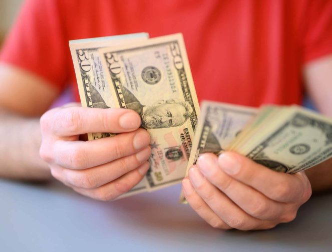 men-s-hands-hold-and-count-50-dollar-bills-on-gray-2022-11-14-02-08-02-utc.jpg
